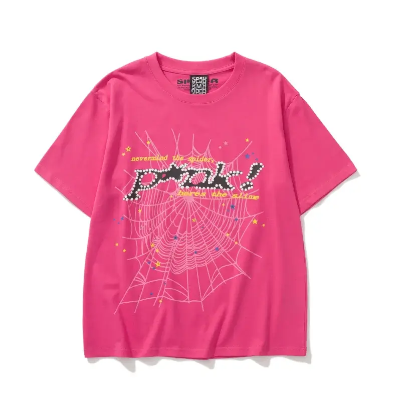 Hot pink Sp5der P*NK t-shirt laid flat, with a black studded P*NK wordmark, yellow typewriter text and a pale pink spider web spread across the front